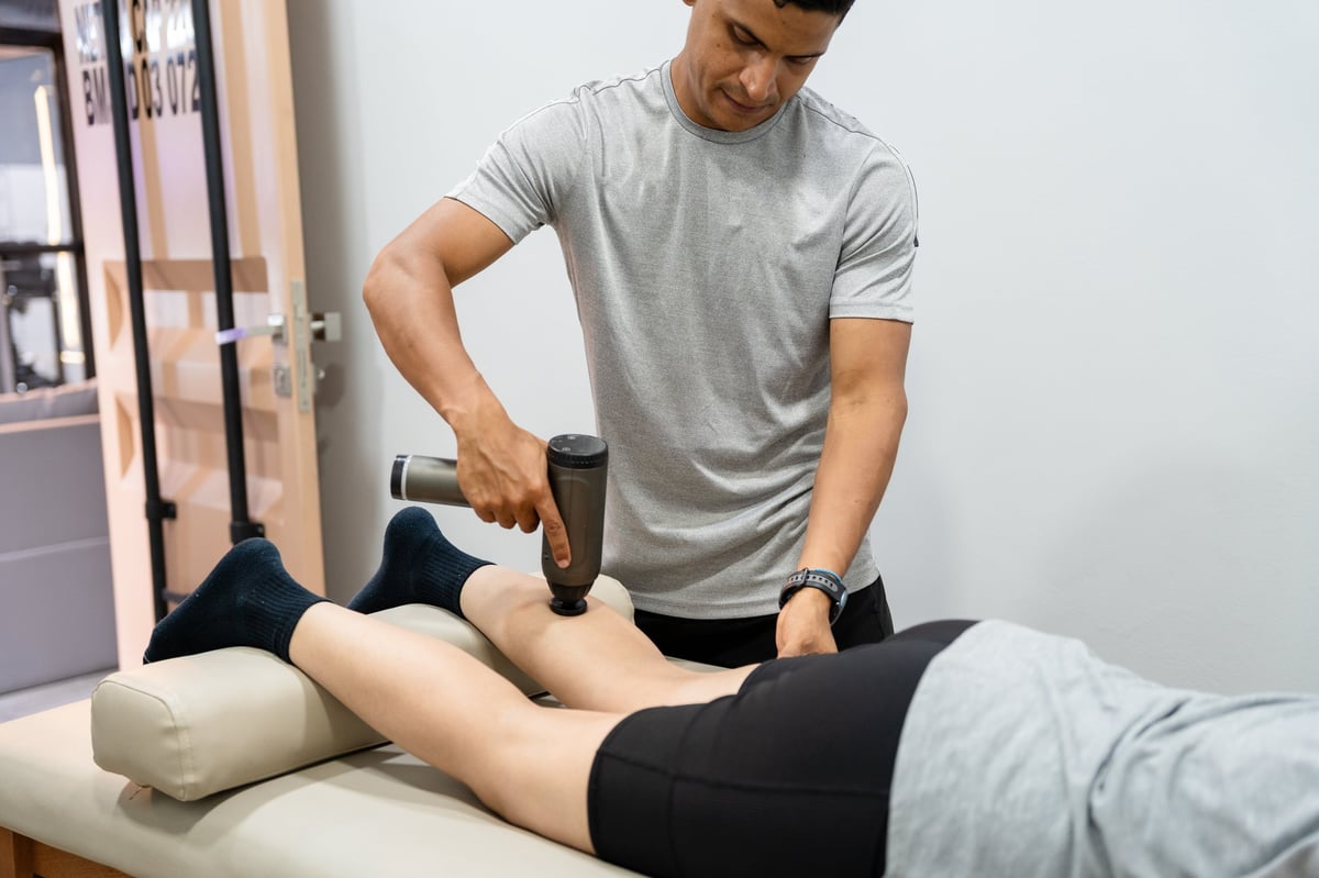A therapist applying deep pressure to a client's leg during treatment
